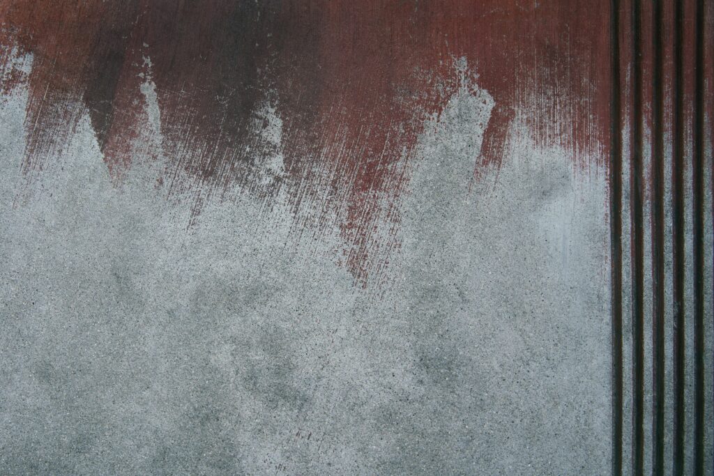 Close-up of a textured wall with abstract paint strokes and vertical stripes, showcasing concrete surfaces.